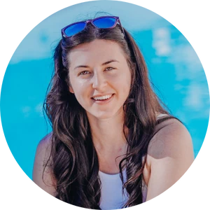 Sally, a white woman smiling at the camera with a swimming pool in the background.