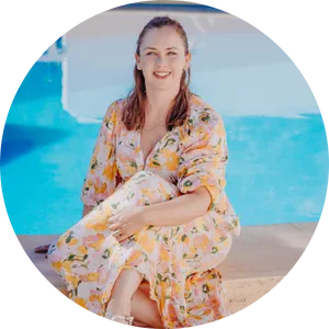 Vicky, a white woman sitting with her back to a swimming pool enjoying a business retreat in Spain