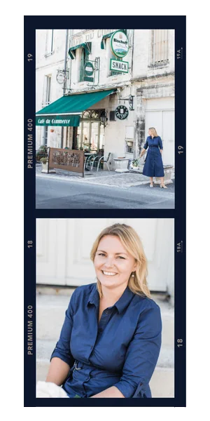 Kate, in a blue dress walks by a café, where consulting firms for small businesses are often discussed, and sits smiling on a bench. White buildings and café signs are visible in the background.