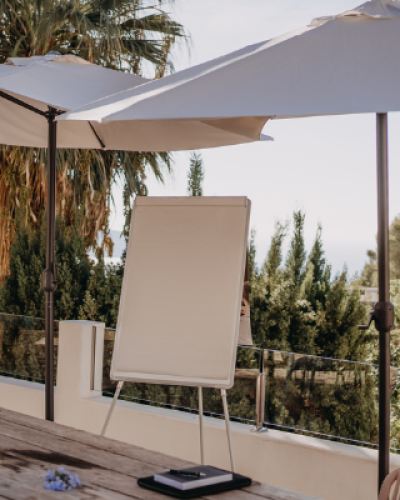 Outdoor terrace with umbrella, whiteboard, and pool at the retreat venue.